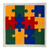 Colorful puzzle piece rug with red, orange, green, and blue pieces on a neutral background